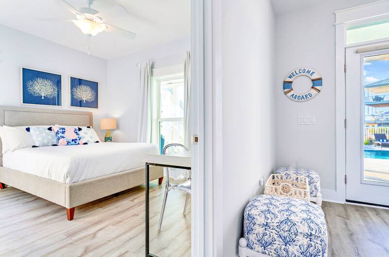 Queen bedroom with blue art and a door to the pool